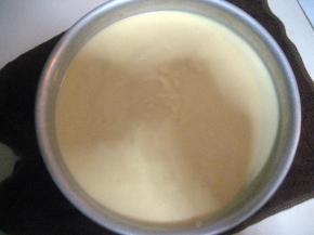 然后把面糊倒入模具内，提起模具在案上轻磕数下，震去面糊中的气泡；