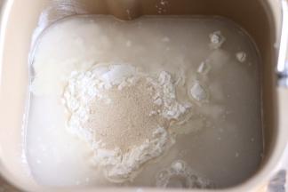 把面粉，水，酵母放入面包机桶，启动和面功能，揉至面团光滑。