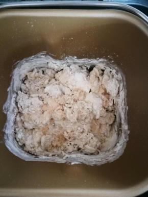 加入水和酵母，用筷子搅拌一下，不然一会面包机工作起来，粉会扑出来。搅拌好后，启动揉面程序，1分钟就可以取出来接着用手揉了。面团偏硬，面包机揉不动的，我这是起到搅拌作用。用手是完全可以的，更方便。新手一定用手揉面团，太硬的面团会烧坏面包机的。