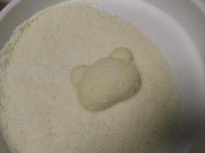 把南瓜饼放入椰蓉中，表面沾一层椰蓉