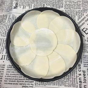 披萨盘涂一层黄油或食用油，放入饺子皮。