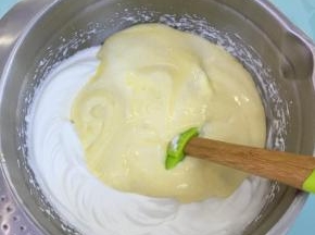 将拌好的蛋糕糊倒入到剩余的蛋白霜中，翻拌均匀。