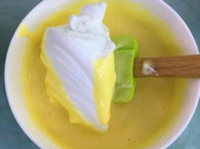 取三分之一的蛋白霜到蛋黄糊里，翻拌均匀。