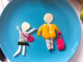 用同样的方法做出女孩的轮廓和衣服。火龙果皮剪好女孩的包包和男孩的行李箱。