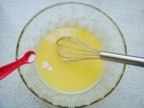 用手动打蛋器顺时针搅拌均匀至糖融化，加入苏打粉和泡打粉，再次搅拌均匀。