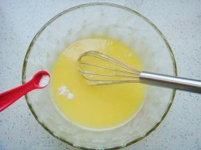 用手动打蛋器顺时针搅拌均匀至糖融化，加入苏打粉和泡打粉，再次搅拌均匀。