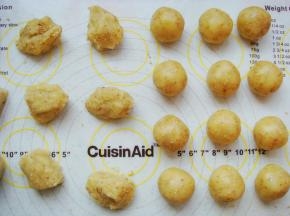 把面团平均分成35克一个的小剂子，放在手心里团成光滑的小圆球。