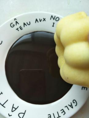 平盘倒入巧克力酱，拿一个烤好的甜甜圈沾满巧克力酱。