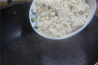 锅内放水烧开，放入内酯豆腐焯水。水开之后调成中火，将豆腐轻轻的顺着锅边倒下去，煮4分钟左右就可以捞出，煮的时候不要经常搅动，以免豆腐弄得太碎