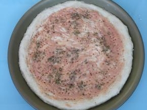 挤上番茄酱和甜味沙拉酱抹匀，撒上披萨草。