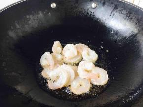 炉灶上置不粘锅，待锅微热时放入约30g的炒菜油，待油5～6成热的时候放入腌制好的虾仁。
