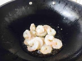 炉灶上置不粘锅，待锅微热时放入约30g的炒菜油，待油5～6成热的时候放入腌制好的虾仁。