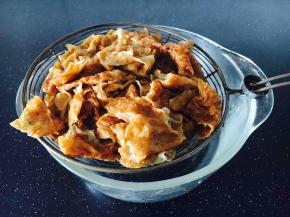 用汤勺压一压笊篱里的面筋，把面筋控干水份备用。