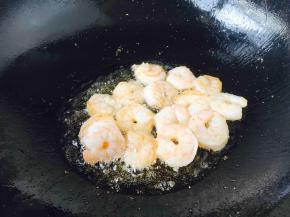 刚放入虾仁时先别翻炒，当离火晃动锅时，虾仁能滑动，不粘在锅上时即可翻炒，当虾仁颜色变成粉红色就盛出来。