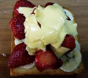 再把草莓和奶酪片放在香蕉片； 放入180度烤箱中层，等奶酪片融化上色后取出。