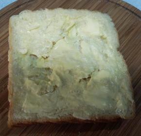 吐司片表面划几刀，不要划断。抹上软化的黄油。