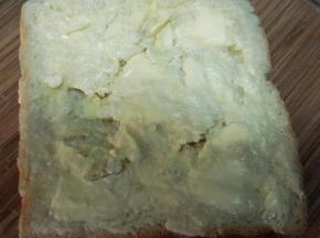 吐司片表面划几刀，不要划断。抹上软化的黄油。