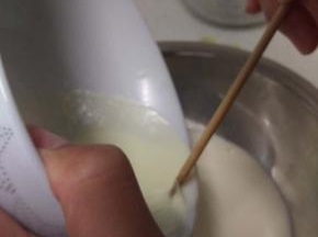 用筷子顶住奶皮，慢慢把奶倒出来留住奶皮，这时候碗还要有热度，不能全凉，不然后面奶皮会粘在碗上面。