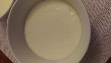 把搅拌好的牛奶再慢慢顺着碗边倒入有奶皮的碗里，奶皮会慢慢浮上来。然后加个保鲜膜。把锅烧开水后把碗放在上面蒸，蒸的时候开中火蒸20分钟。