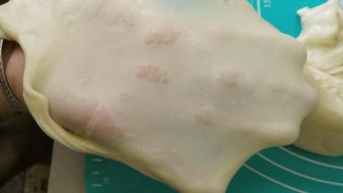 我是面包机揉不出手套膜，所以用手工搓揉+摔打法揉到面团完全扩展的，完全扩展的面团就可以拉出手套膜了，做土司的话一定要出膜，要不然就没有拉丝