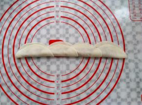 从右往左依次盖上饺子皮的另一边