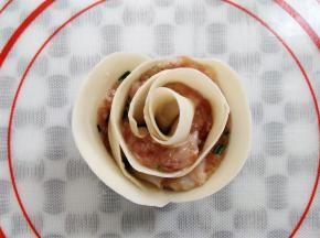 卷好的玫瑰花饺子边上沾一点水，让饺子皮黏合，一朵含苞欲放的漂亮玫瑰花饺子就做好了