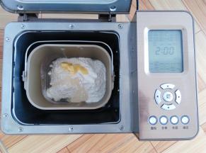主配方材料中除黑芝麻以外，按照先液体再粉末的顺序放入面包桶内，酵母放面粉上，黄油放一侧，启动面包机和面28分钟