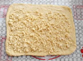 面团擀成一张大的面皮，尺寸是36*26cm左右，撒上椰蓉馅，上边预留2cm空白，其他3边预留1cm空白