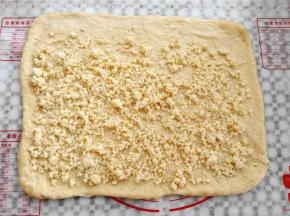 面团擀成一张大的面皮，尺寸是36*26cm左右，撒上椰蓉馅，上边预留2cm空白，其他3边预留1cm空白