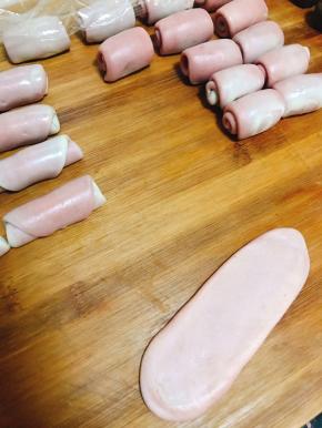 擀成牛舌状。从下用手心搓起，大致能卷起3-4圈。

全部擀好后盖膜松弛20分钟。

然后重复上一步骤，把面擀成牛舌状，卷起，盖好膜，松弛20分钟备用。