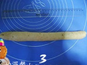 3、然后将面团压扁排气，搓成30cm的长条