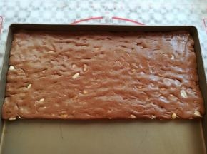 把混合均匀的牛轧糖倒入到不沾的烤盘（或者油纸上）