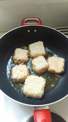 锅烧热油，中大火。把包好的土豆饼裹一层面包糠拿进锅里煎