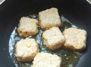 锅烧热油，中大火。把包好的土豆饼裹一层面包糠拿进锅里煎