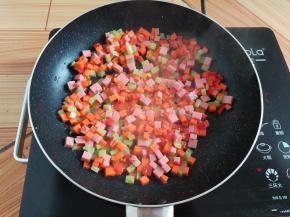 锅里放入少量油翻炒一下蔬菜丁和火腿肠丁