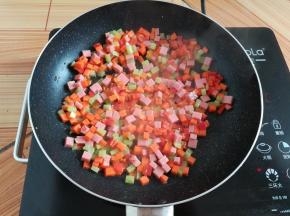 锅里放入少量油翻炒一下蔬菜丁和火腿肠丁
