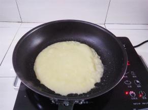 小火加热，面糊凝固到变成蛋饼冒泡的时候用硅胶刮刀铲一下边缘，蛋饼能轻松滑动就可以出锅了（准备一块湿毛巾，煎好蛋饼的的锅放湿毛巾降温，煎出来的蛋饼不容易有焦斑）