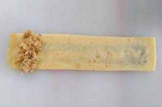 蛋饼翻面，左侧放上肉松，从左向右卷起来