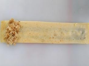 蛋饼翻面，左侧放上肉松，从左向右卷起来