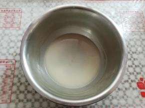 准备一只干净的小盆，依次放入水，奶粉，糖10克，玉米油，用手动打蛋器快速搅拌到盆内液体完全乳化