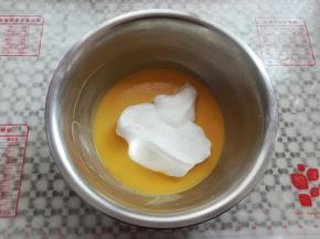 取三分之一蛋白霜放入蛋黄糊，2-8点钟方向手法翻拌均匀