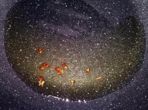 玉米油倒入锅中，放十几粒花椒，小火炸出香味后，将花椒捞出。