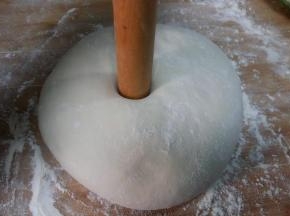 发好的面团，揉搓至面团切面无气孔，收圆。用擀面杖插入面团中间。