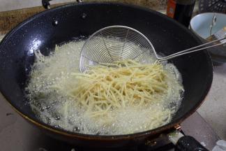 下入土豆丝油炸，少量多次放完土豆丝，不要一口气都丢进锅