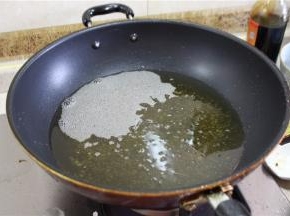锅里倒油，烧至七成油温