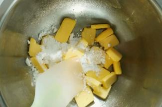 糖粉加入到黄油里面，用刮刀将黄油跟糖粉搅拌均匀，以免呆会打发黄油的时候溅到外面