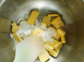 糖粉加入到黄油里面，用刮刀将黄油跟糖粉搅拌均匀，以免呆会打发黄油的时候溅到外面