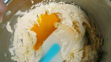 鸡蛋分两次次加入，每加入一次就用打蛋器搅拌均匀，完全与黄油融合