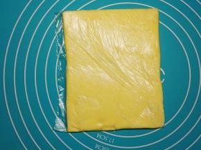 找一个小号保鲜袋，把80g黄油切片放入袋子里，擀成厚薄一样的方形黄油片，放入冰箱冷冻10分钟