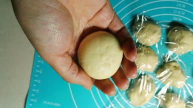 将底部的口收好，可以用手将面团粘在一起，然后利用手心将面团在桌面上滚圆